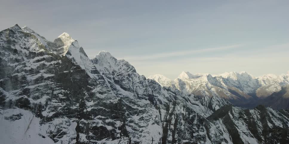 A vast, snow-covered mountain range under a clear sky
