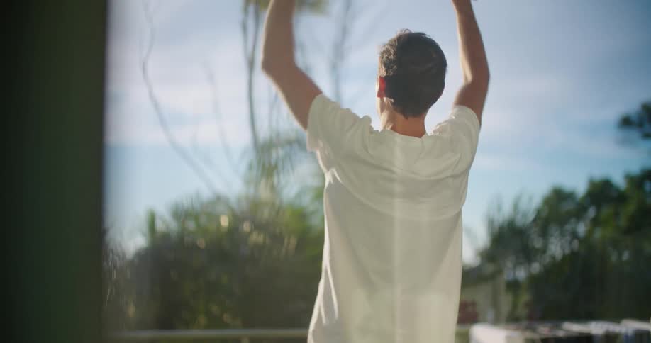 A man lifting weights outdoors in the middle of the day