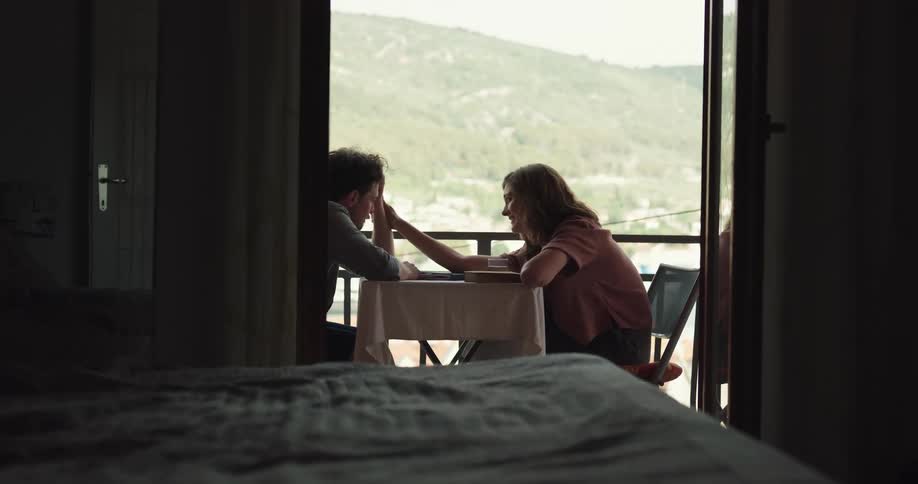A man and woman aretalking and sitting at a table