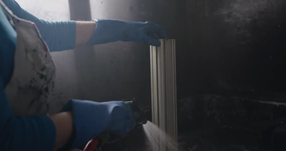 A woman is spraying down an object with a hose