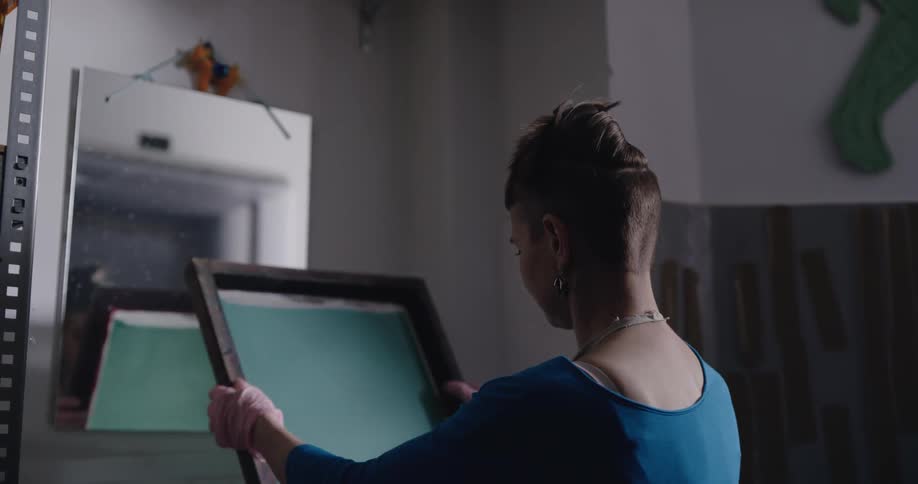 A woman looking at a painting in a frame