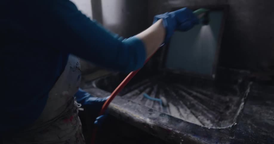 A woman spraying down a canvas