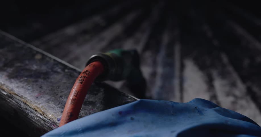 A room with a hose gloves and a brush