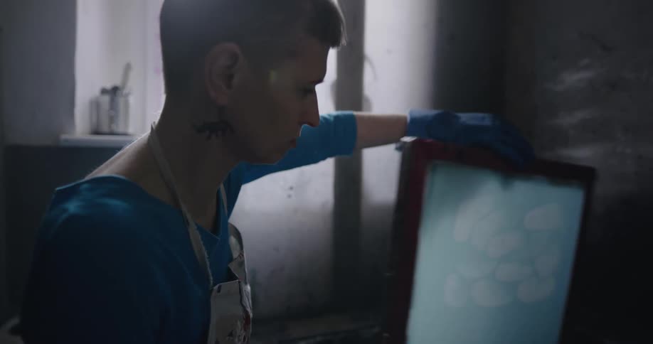 A woman is standing in a room and washing a picture frame