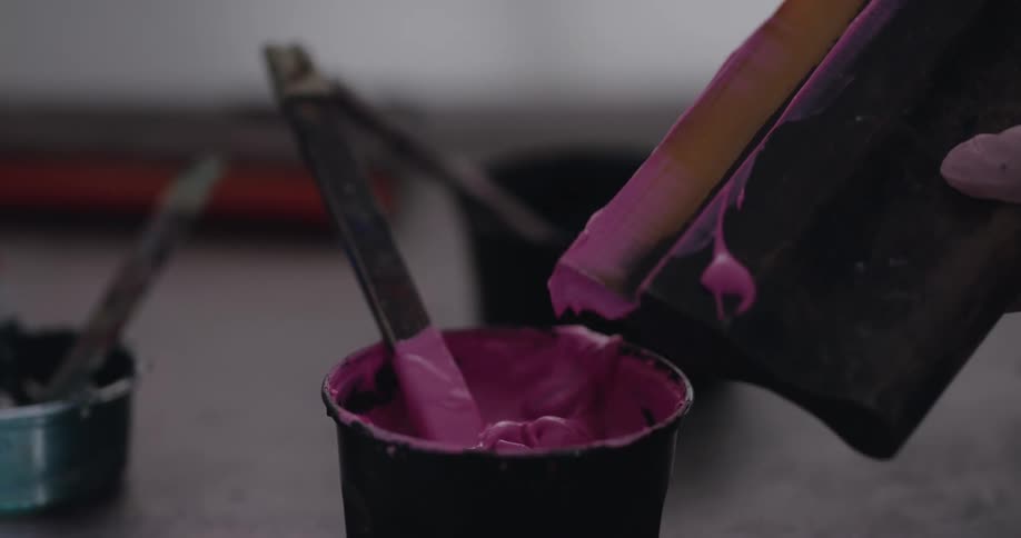 A person is cleaning paint off an object