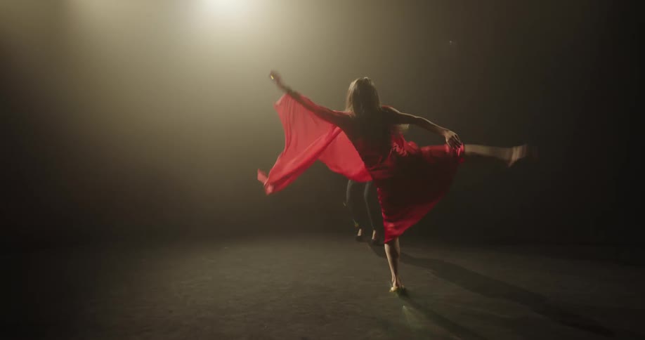 A woman dancing on a stage indoors