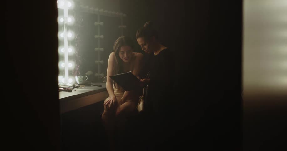 A woman walks in to a teenagers dressing room and shows her information on a clipboard
