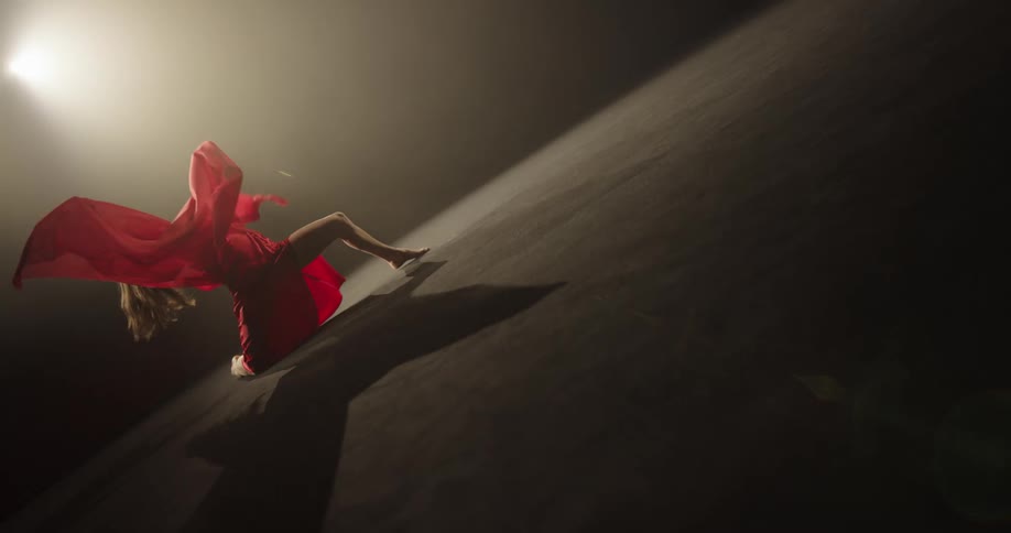A woman is dancing on the dark stage