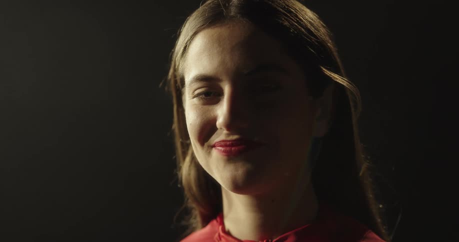 A woman smiles while wearing red lipstick that matches her dress