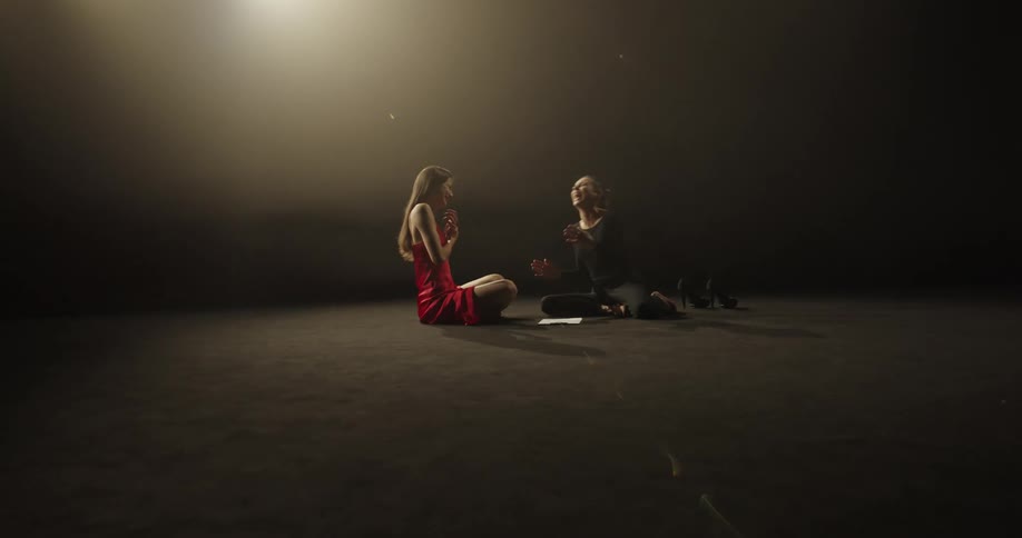 Two friends are sitting on the ground and talking