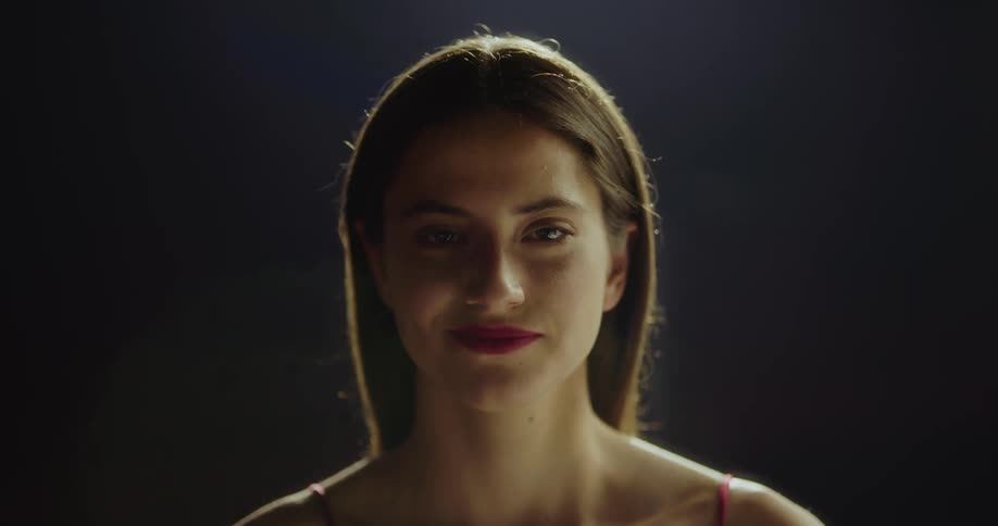 A woman is standing in a room and smiling