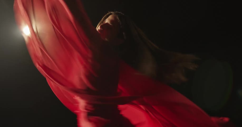 A young woman spins around as she dances on stage