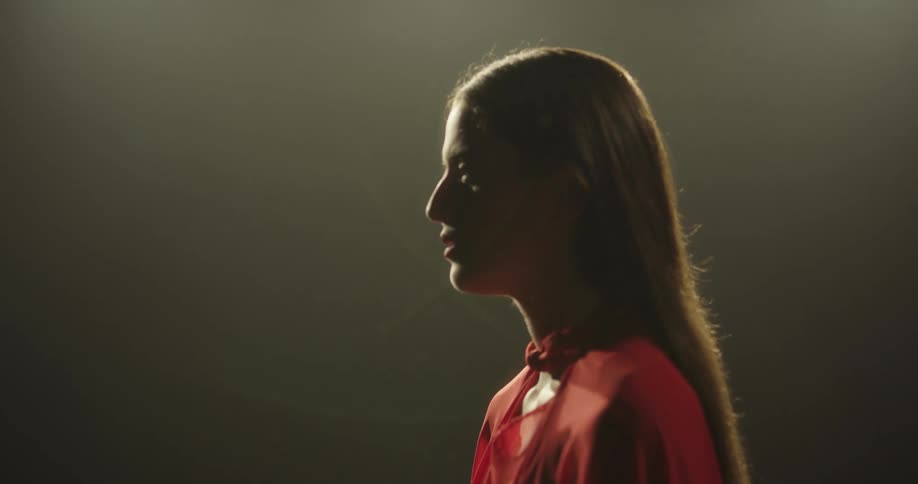 A woman in a room with a wall in the background