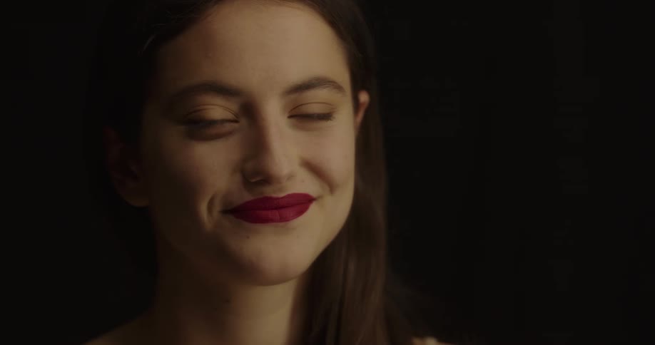 Woman puts lipstick on then smiles