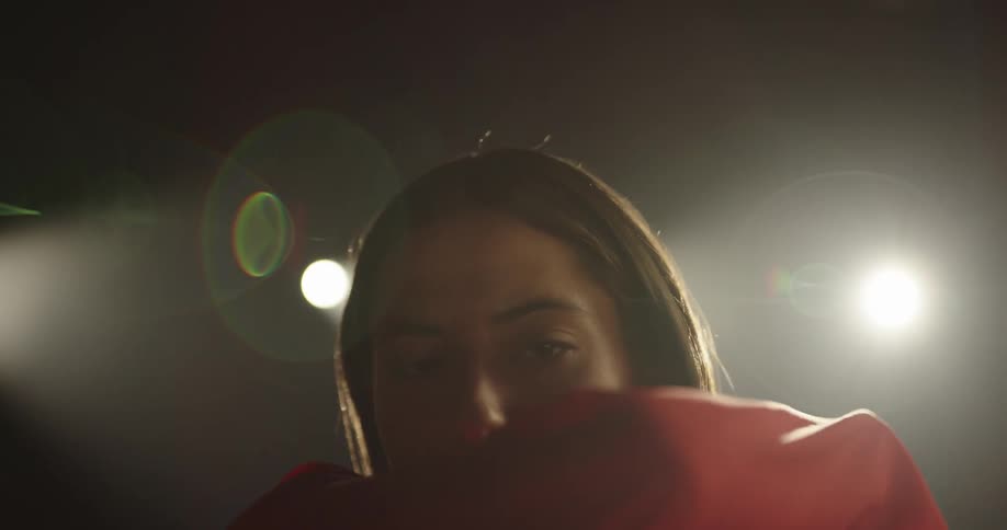 A model poses with a red scarf that she moves all around her