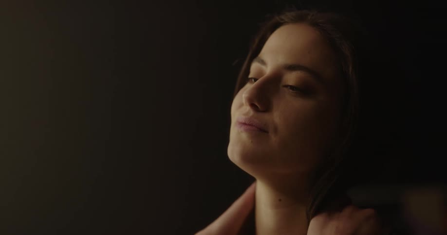 A woman in a room with a wall in the background