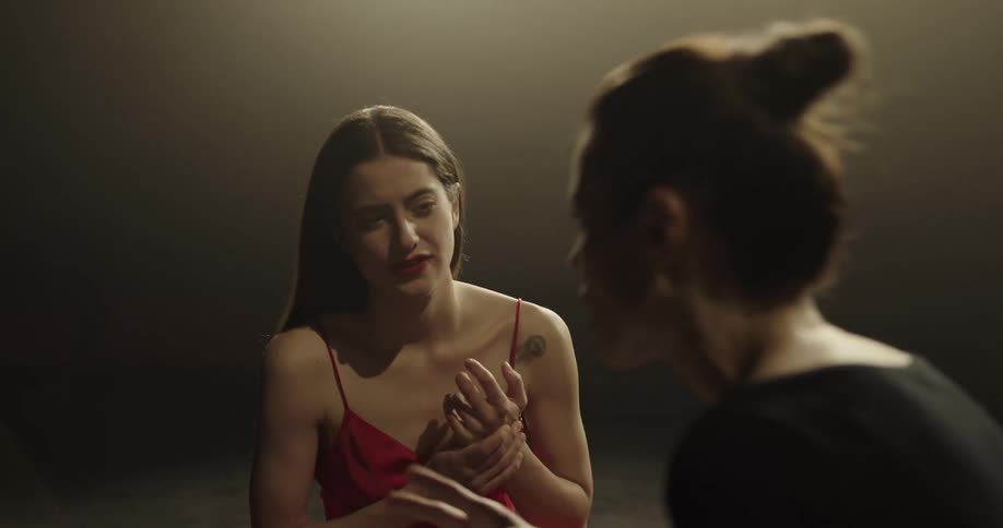 A woman uses her hands as she talks to a teenager that listens