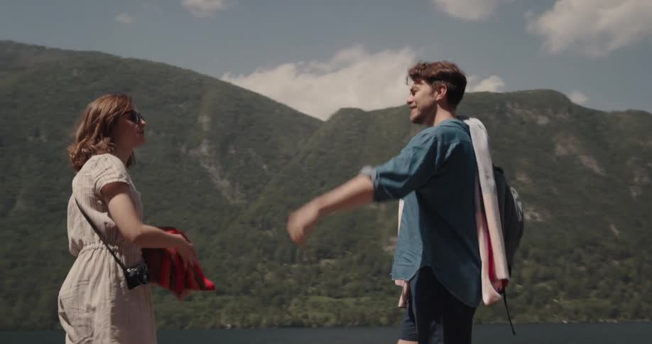 Boyfriend and girlfriend are jogging on a dock towards the lake