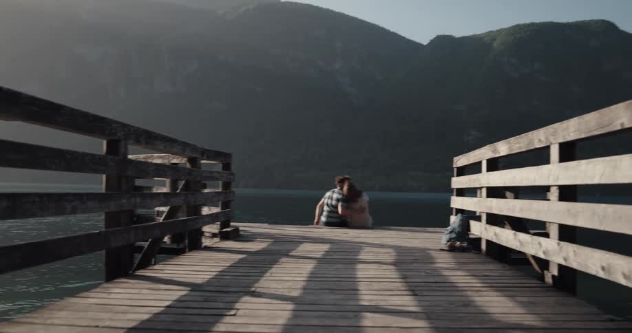 Man and woman are sitting by the lake at dusk