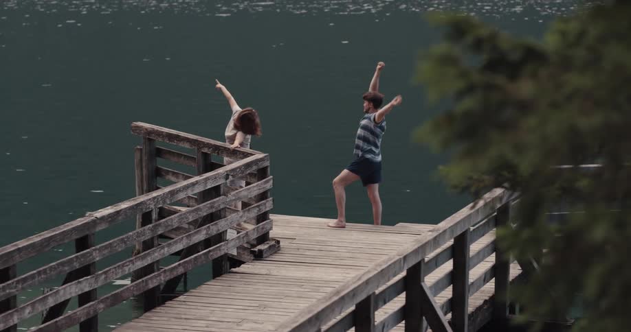 Man and woman are jogging on the dock by the lake