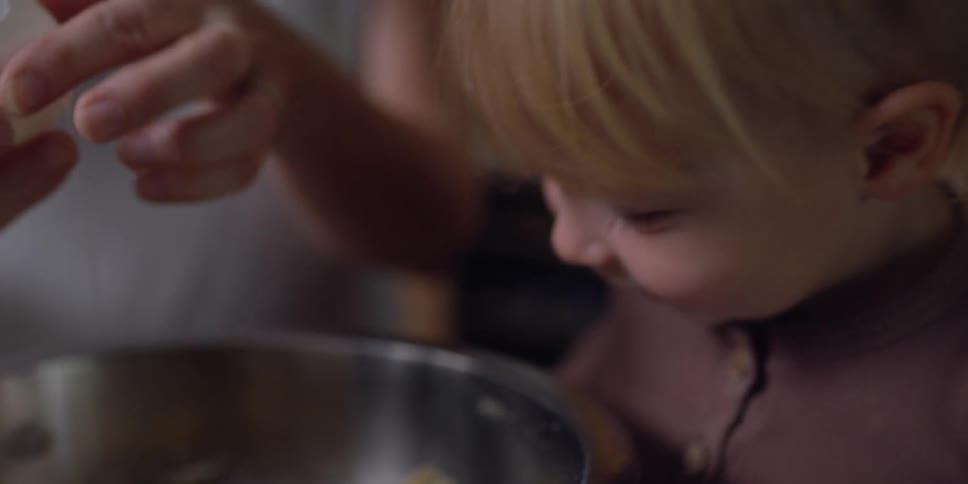 A woman and child cooking in a kitchen