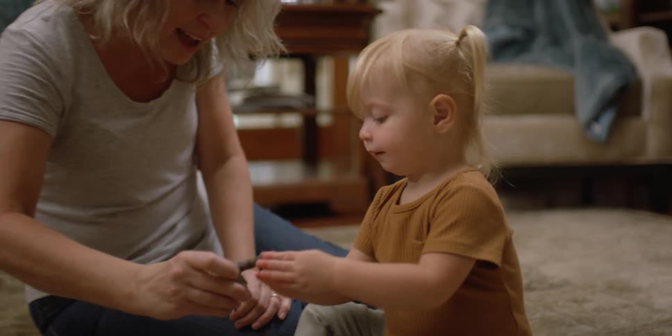 A mother and daughter playing with toys inside