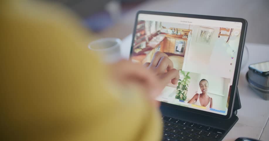 Woman with yellow sweater uses tablet and examines the kitchen design