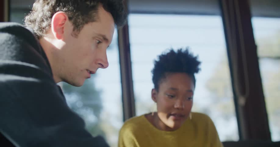 A man and woman sit and look at a laptop together