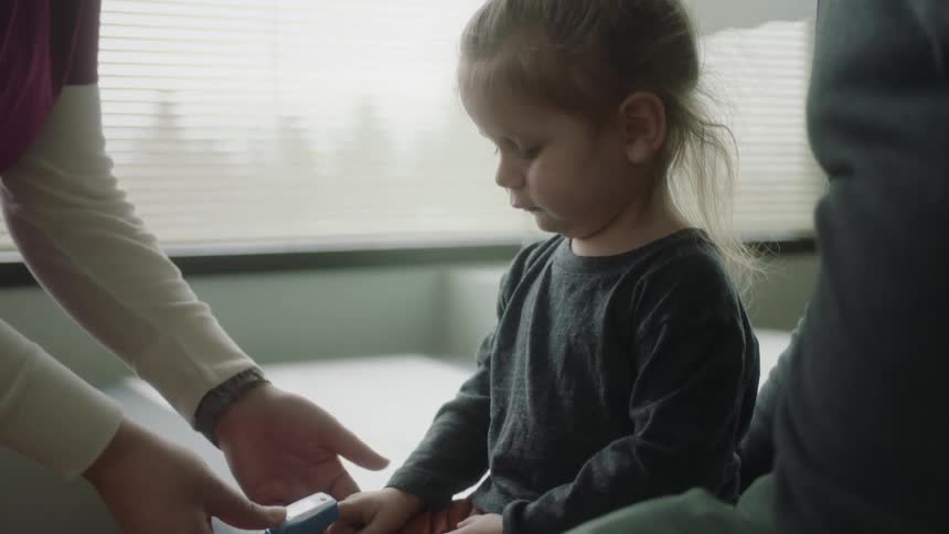 A man a girl and a doctor in a clinic with a window in the background