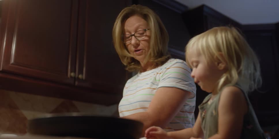 A mother and daughter cooking in a house
