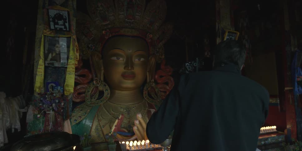 A man is photographing a shrine in a dark area
