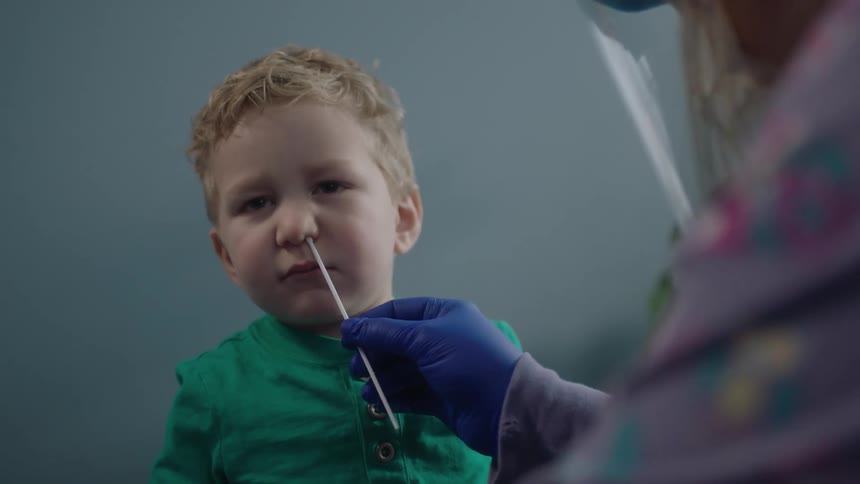 A child getting a swab test taken by a doctor