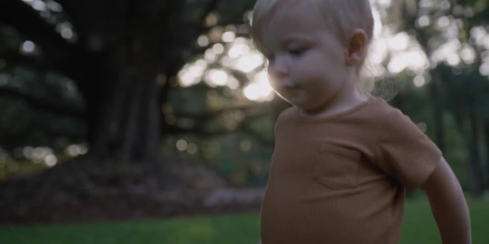 A little girl walks alone through a wooded area