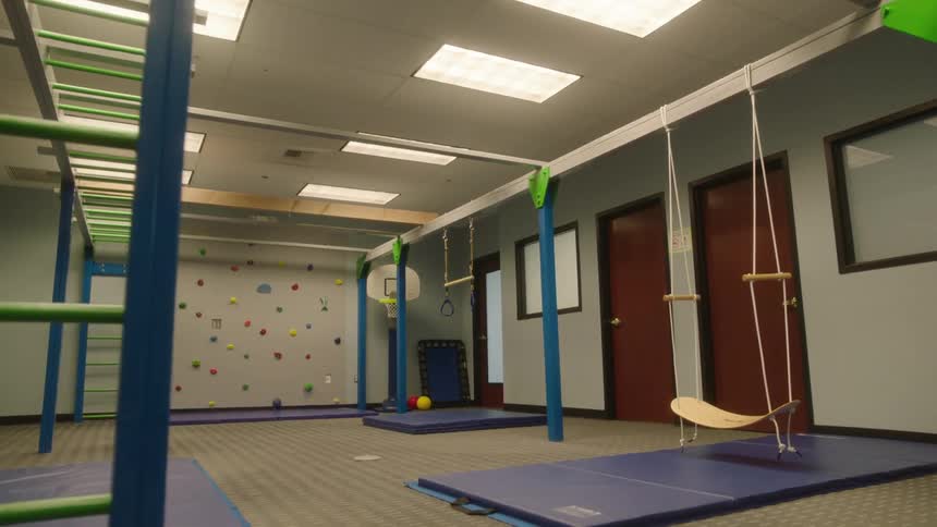 Fitness room with a swing mats climbing wall and ladders