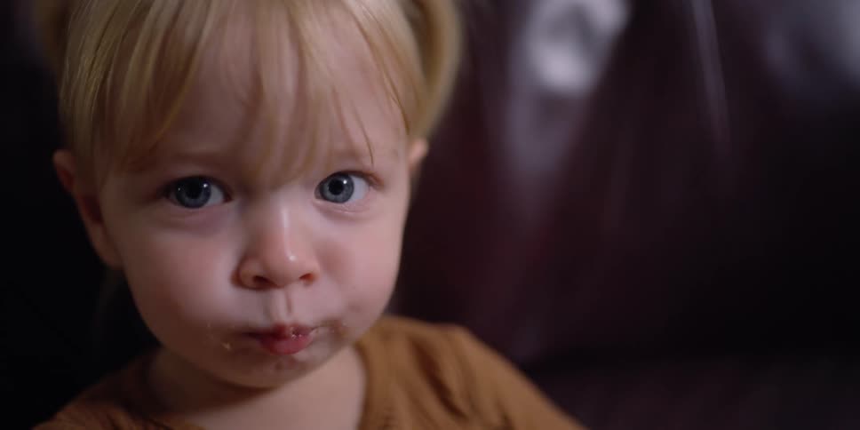 A toddler is eating a cookie