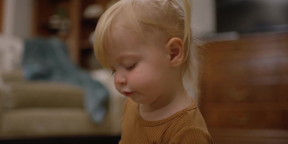 Young girl lines up three toy animals on the floor