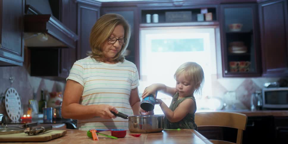 Grandmother and granddaughter cook in the kitchen
