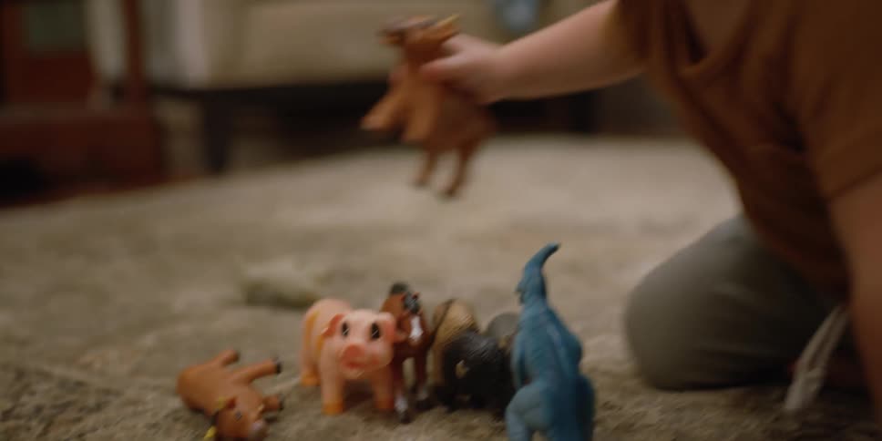Toddler blonde girl plays with toys on the rug