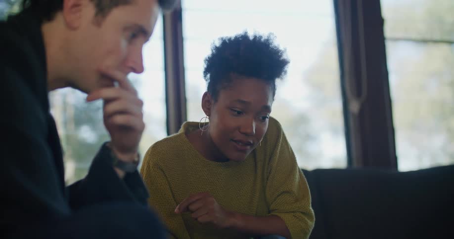 A man and woman talk while using a laptop together