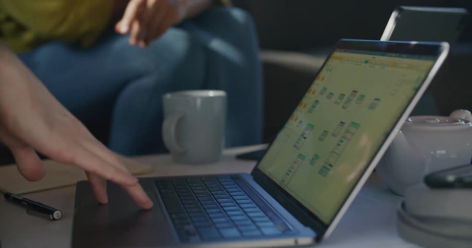 A man and woman look at a laptop and talk