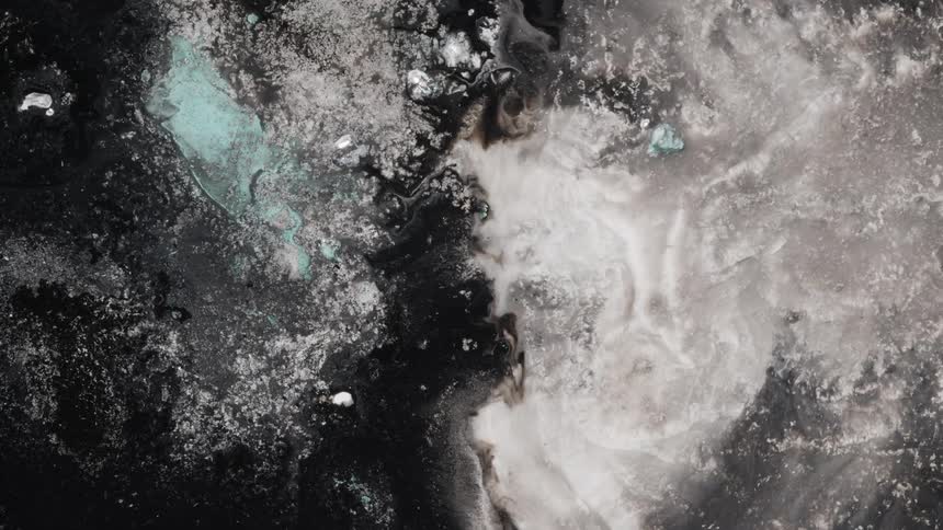 Black and white ink and particles flowing on a water tank in chaotic shapes