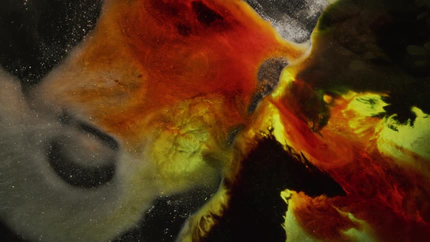 Bright red yellow and grey colors swirl on a dark background
