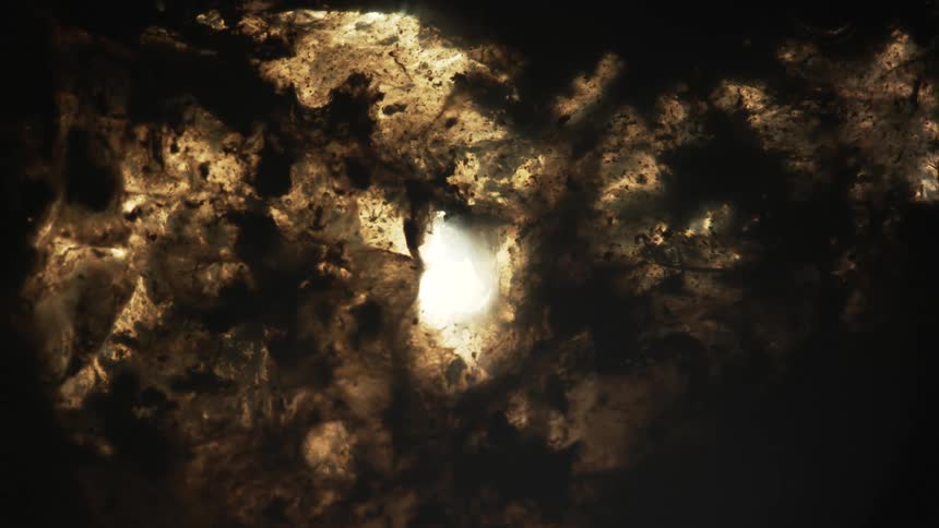 A bubble floats and glows before bursting in liquid