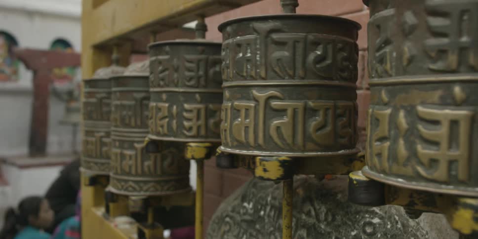 A row of bronze cylinders are spinning