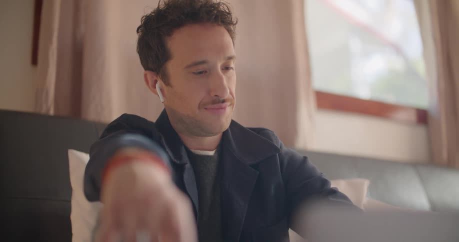 A man sitting on a couch with headphones on