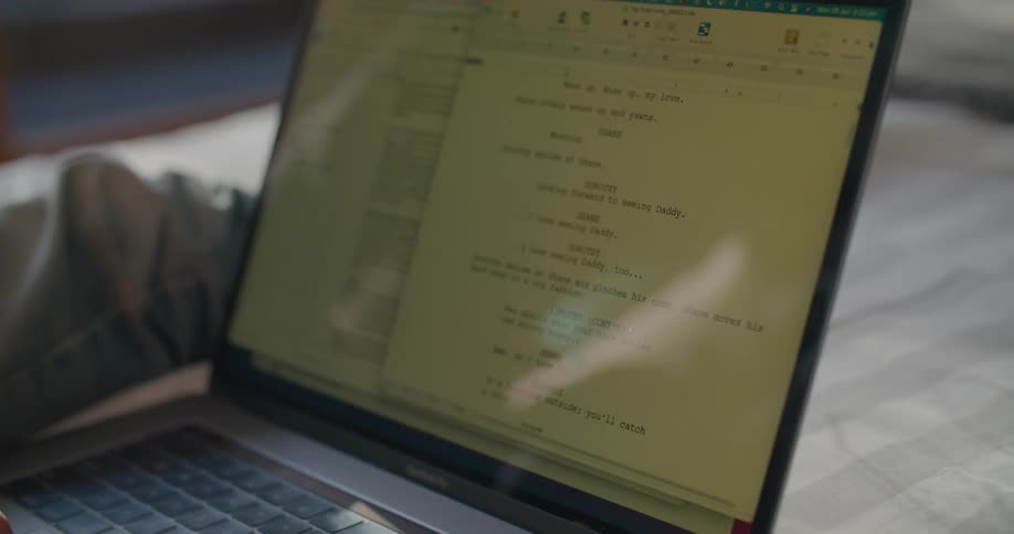 A person is browsing on a laptop and sitting on a bed