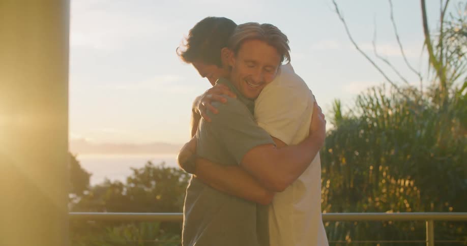 Two men smiling and hugging