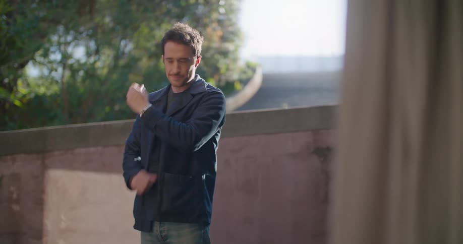 Man stands outdoors near wall waiting