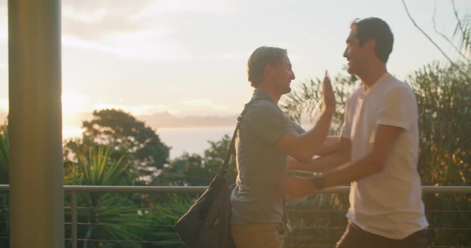 Two men greet each other with a big hug