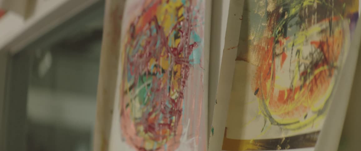 The paintings are hanging on the wall to dry